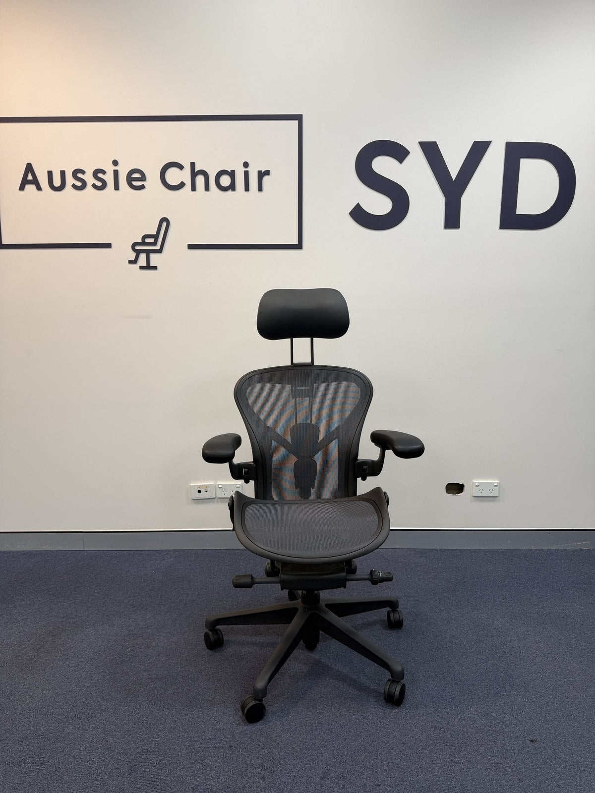 Herman Miller Aeron Size A in Graphite fitted with an Atlas headrest, front view, Aussie Chair Sydney showroom