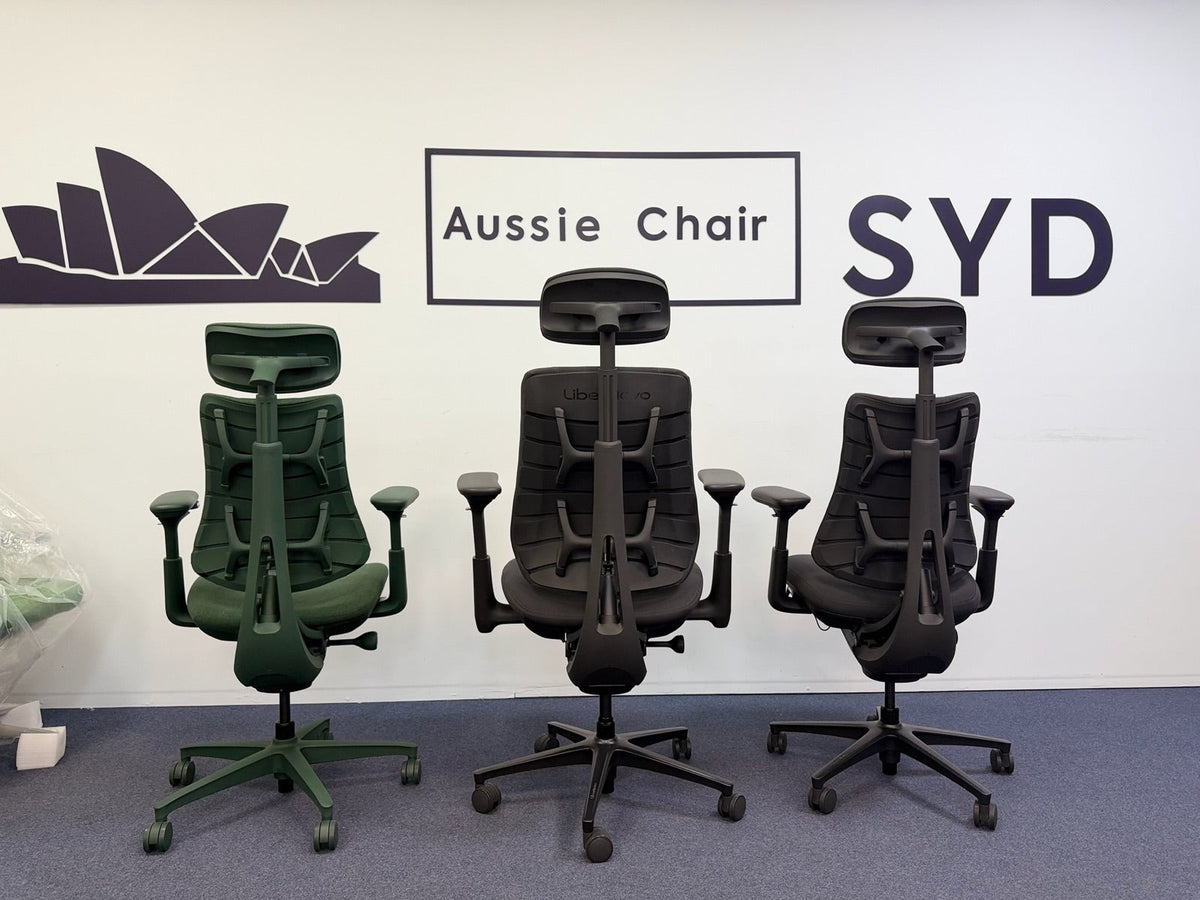 Rear view of the LiberNovo Maxis in the centre between an Omni and an Omni Pro at the Aussie Chair Sydney showroom, showing the Maxis's wider backrest