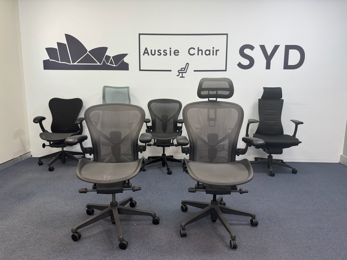 Two Herman Miller Aeron chairs in Graphite with headrests on the Aussie Chair Sydney showroom floor