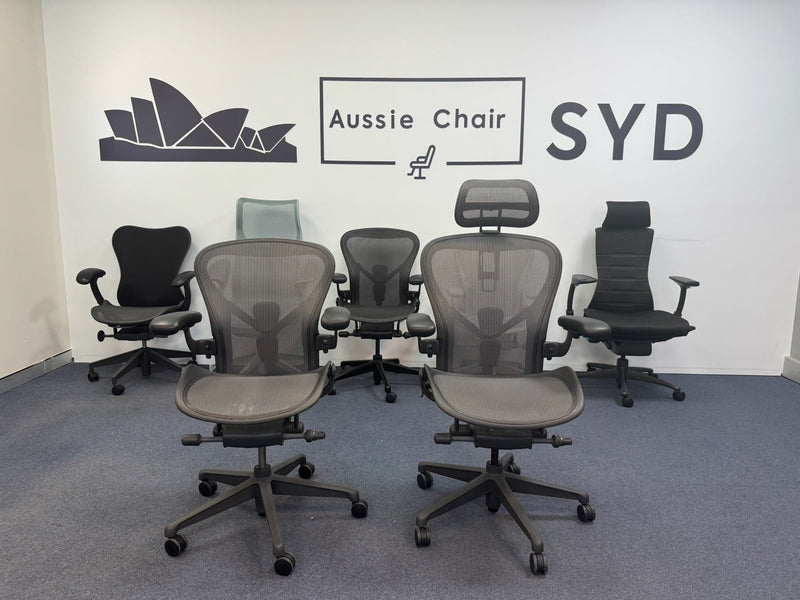 Two Herman Miller Aeron chairs in Graphite with headrests on the Aussie Chair Sydney showroom floor
